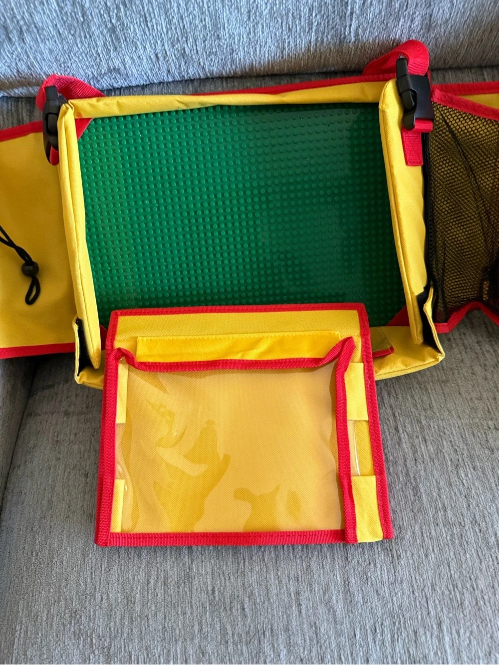 Kids travel activity organizer features a fold-out flat play surface. See detail